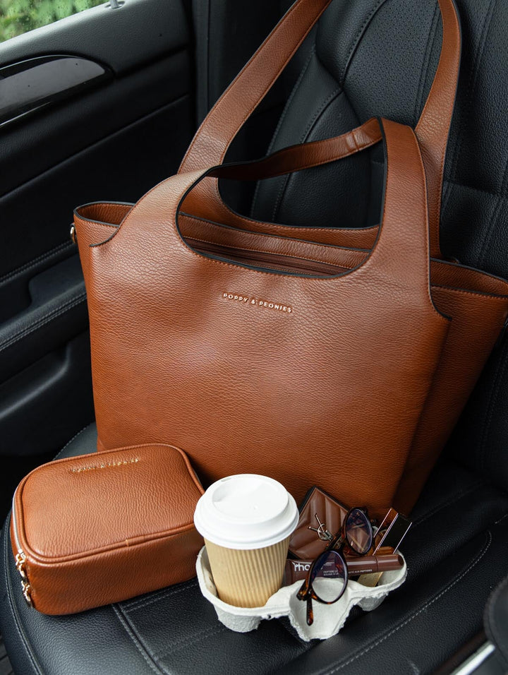Poppy & Peonies Companion Duo in Chestnut displayed on a car seat, featuring The Companion Tote and coordinating Pretty Connected Case.