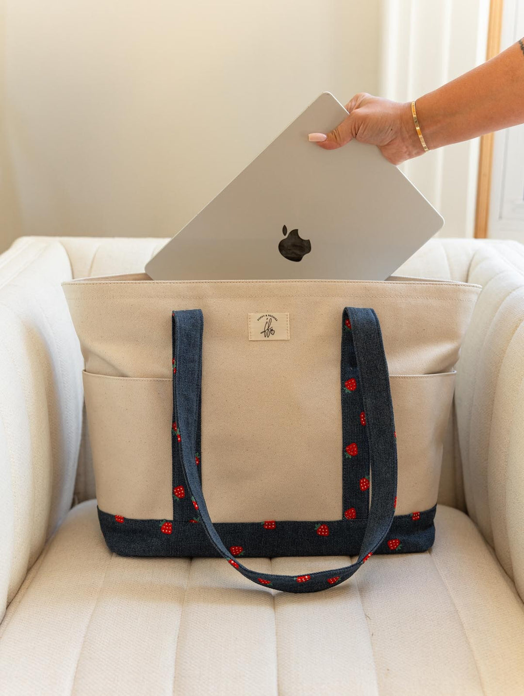 Poppy & Peonies Analog Tote in Strawberry Denim front view with a laptop being placed inside, highlighting the tote’s spacious design and long shoulder straps.