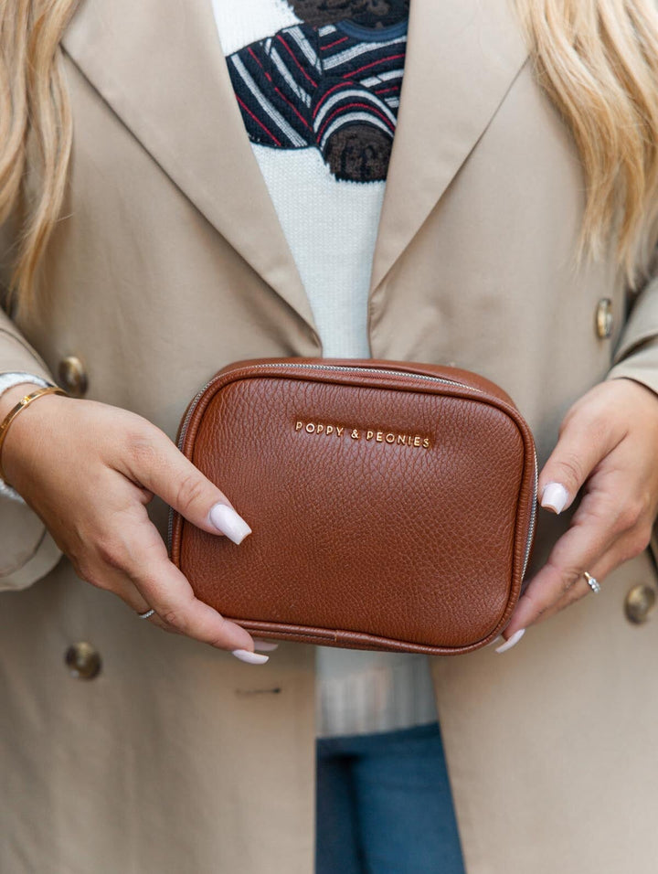 Poppy & Peonies Pretty Connected Case in Chestnut lifestyle close-up, showcasing its compact structured silhouette and gold-tone logo.