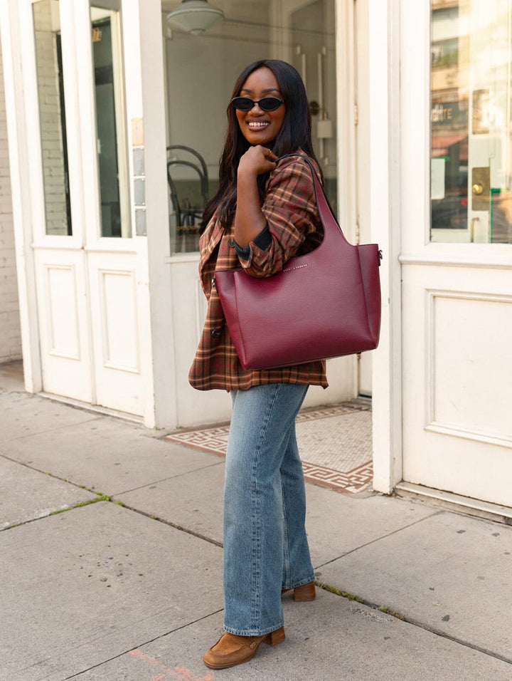 Poppy & Peonies The Companion Tote in Berry worn over the shoulder, featuring comfortable top handles and a structured silhouette.