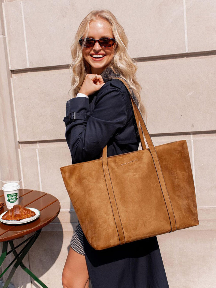 Woman holding a cognac coloured vegan suede leather tote bag outdoors