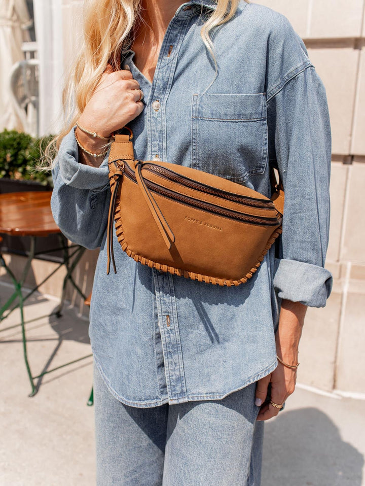 Person wearing a cognac belt bag with a denim shirt 
