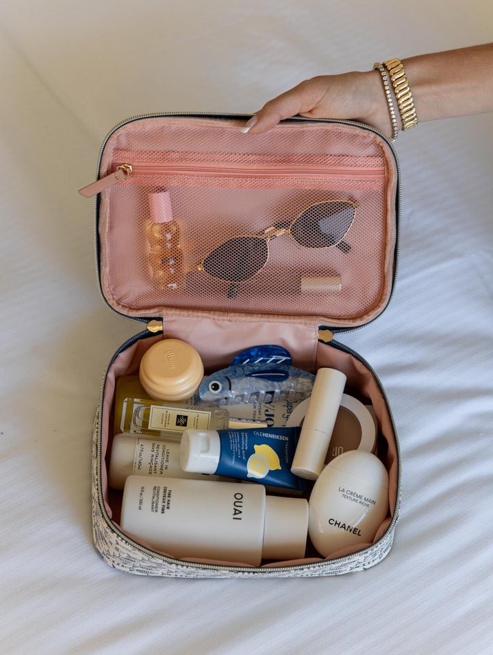 Cosmetic bag with skincare products and sunglasses on a light background