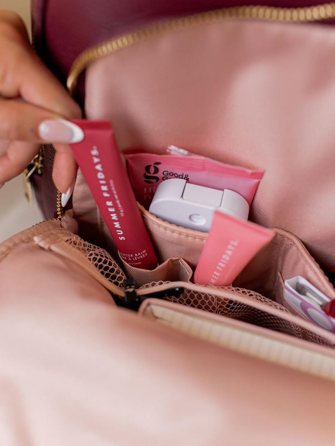 Hand reaching into the front pocket of a backpack.