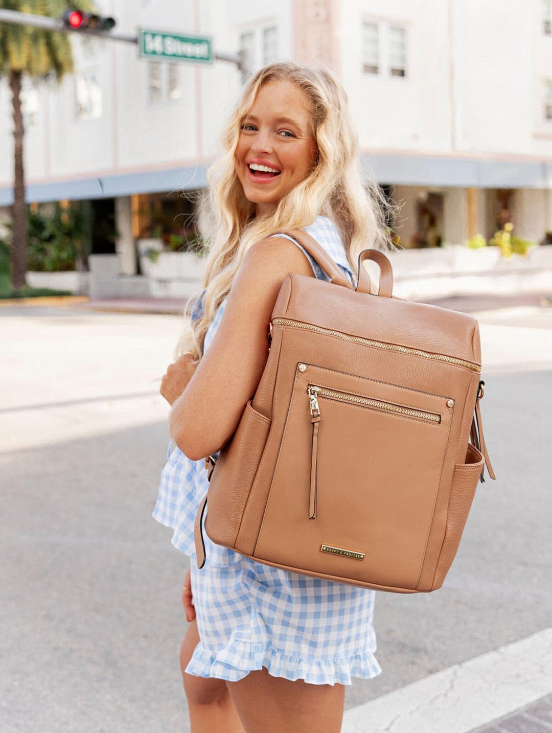 Person wearing light brown vegan leather backpack