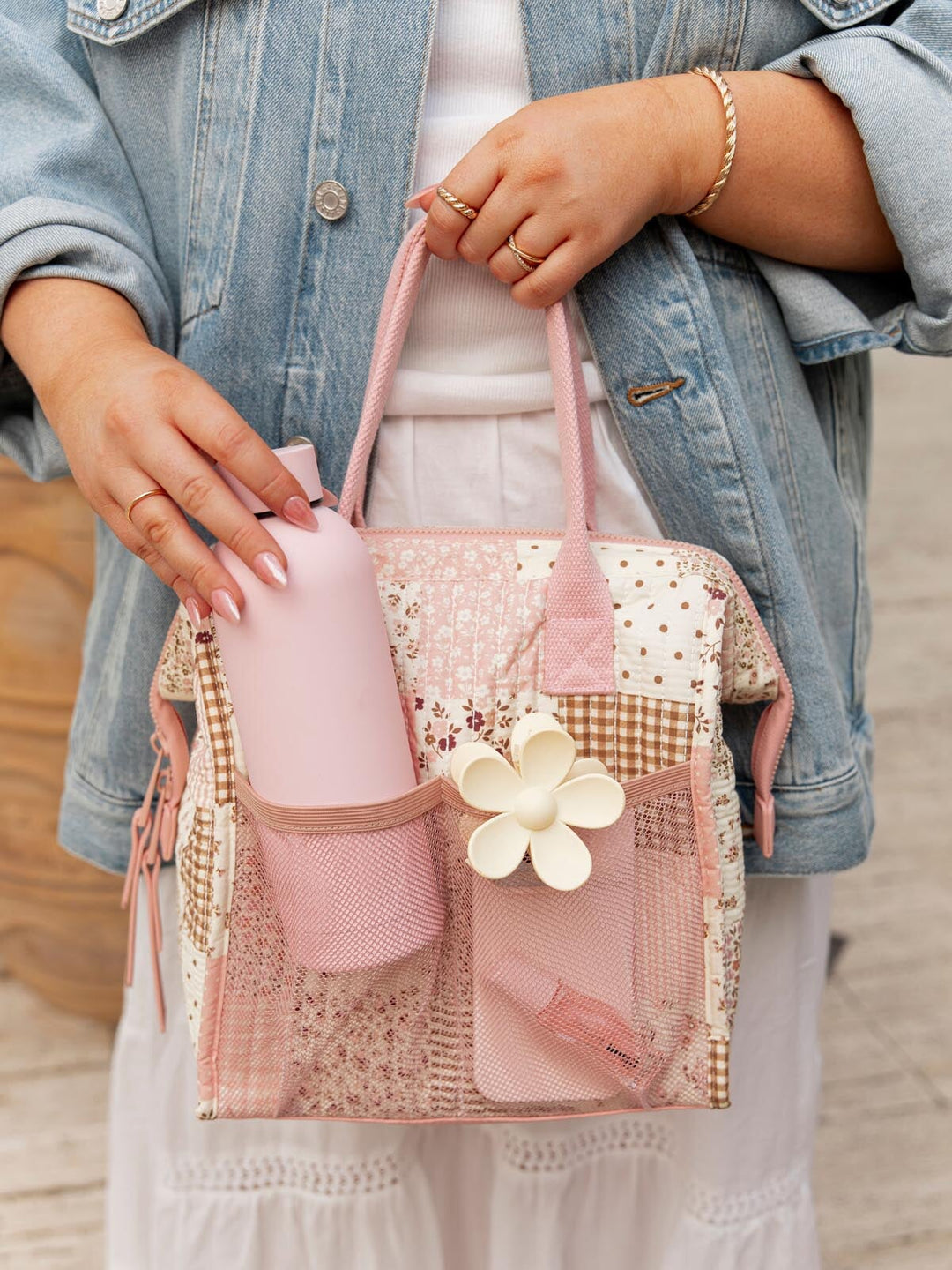 Woman holding a pink patchwork lunch bag with mesh pockets