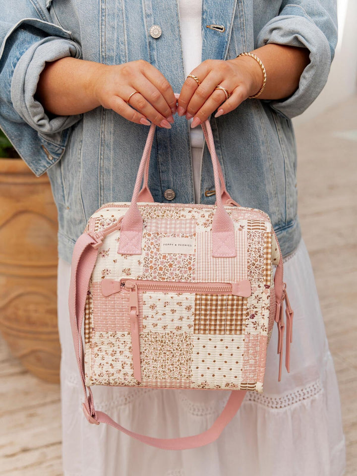 Woman holding a pink patchwork lunch bag