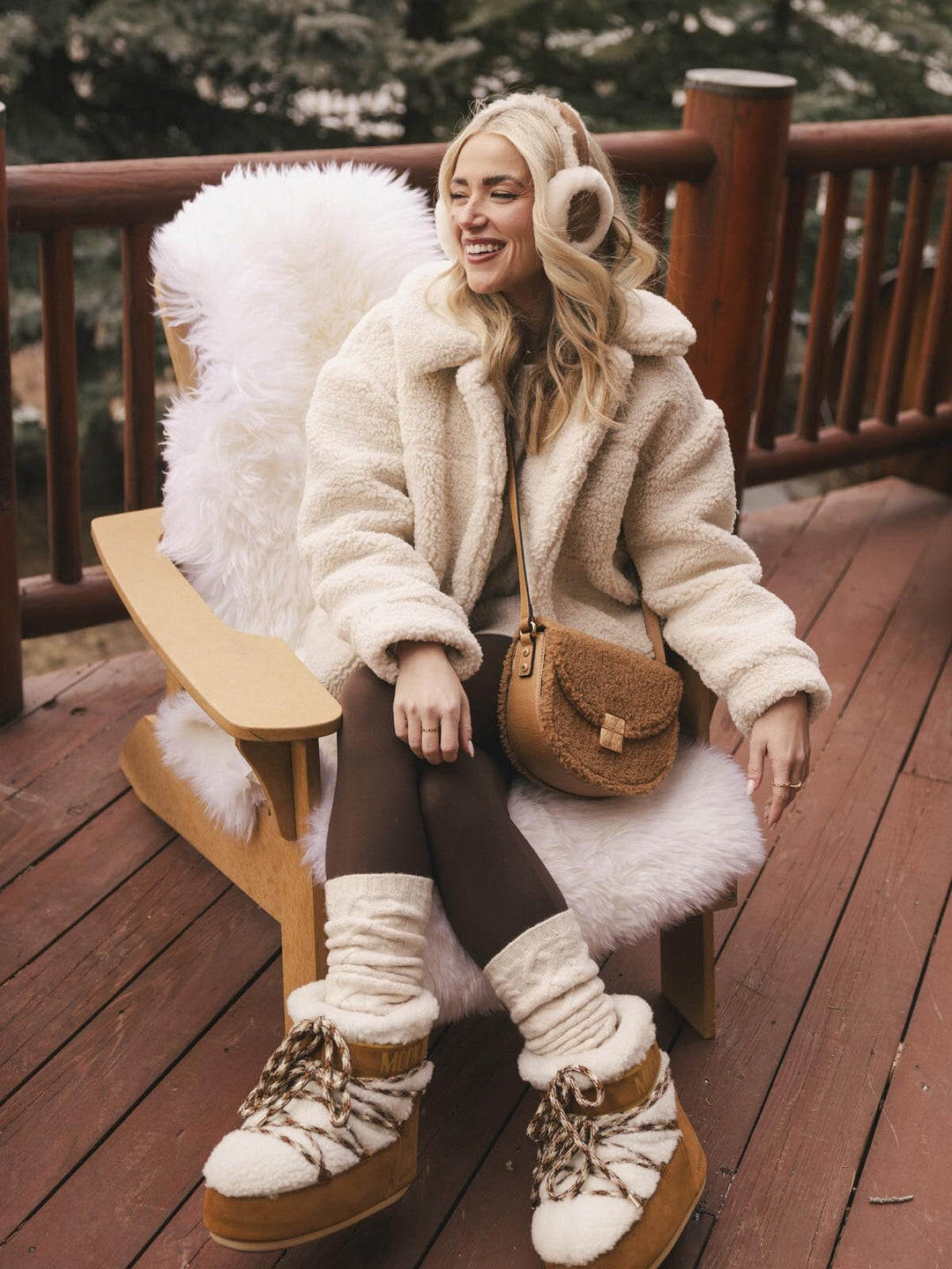 Woman in a fluffy white coat wearing a brown faux fur crossbody bag with a vegan leather strap