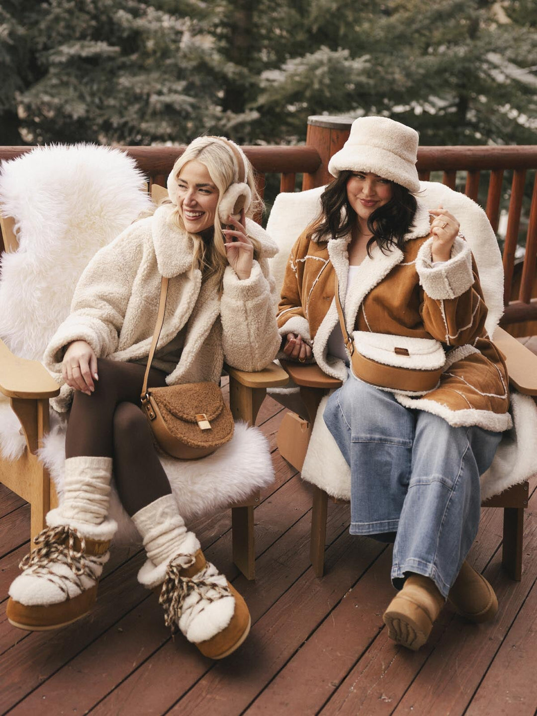 Two women in winter clothing sitting on a wooden deck with matching Poppy and Peonies faux fur bags.