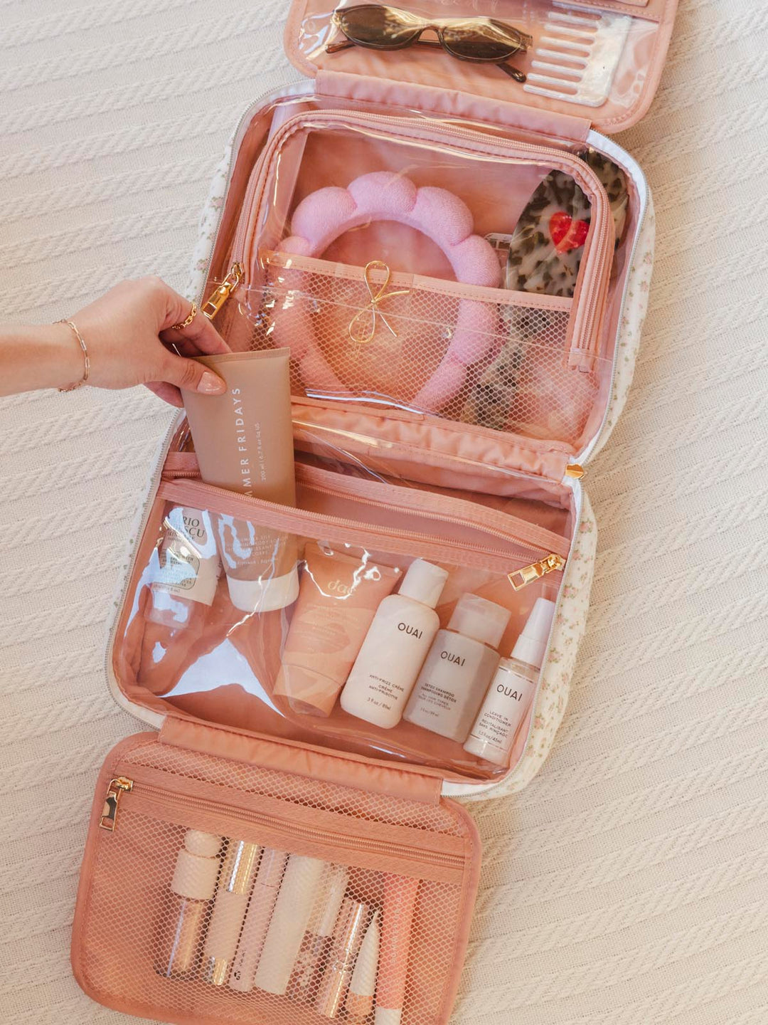 Pink travel makeup bag with skincare products 