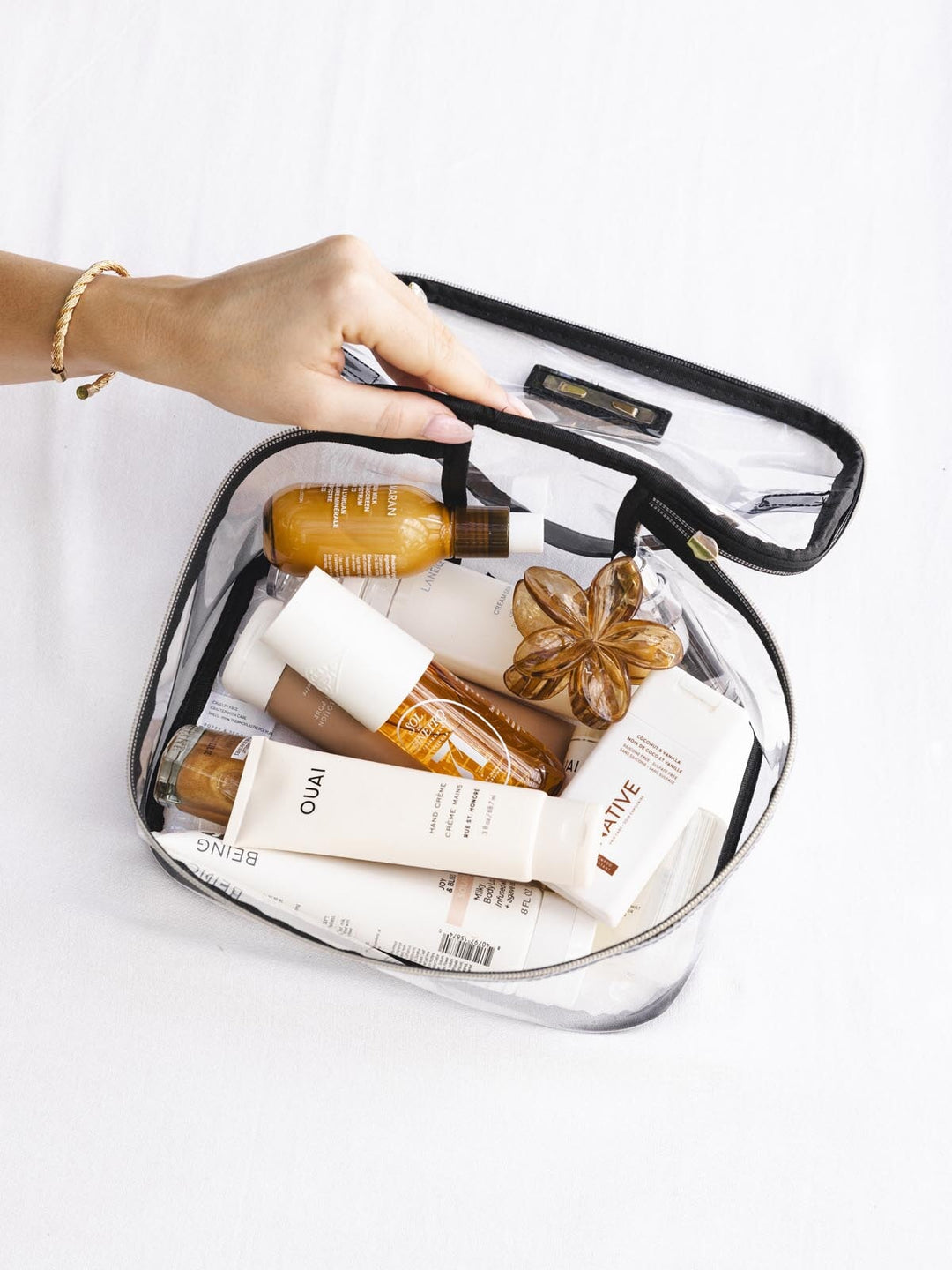 Clear travel pouch with skincare products inside.
