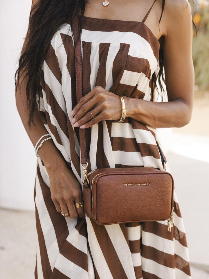 Woman wearing a brown vegan leather crossbody bag
