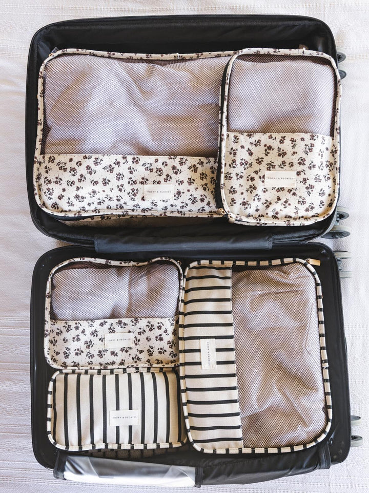 Set of five floral and stripe pattern packing cubes.