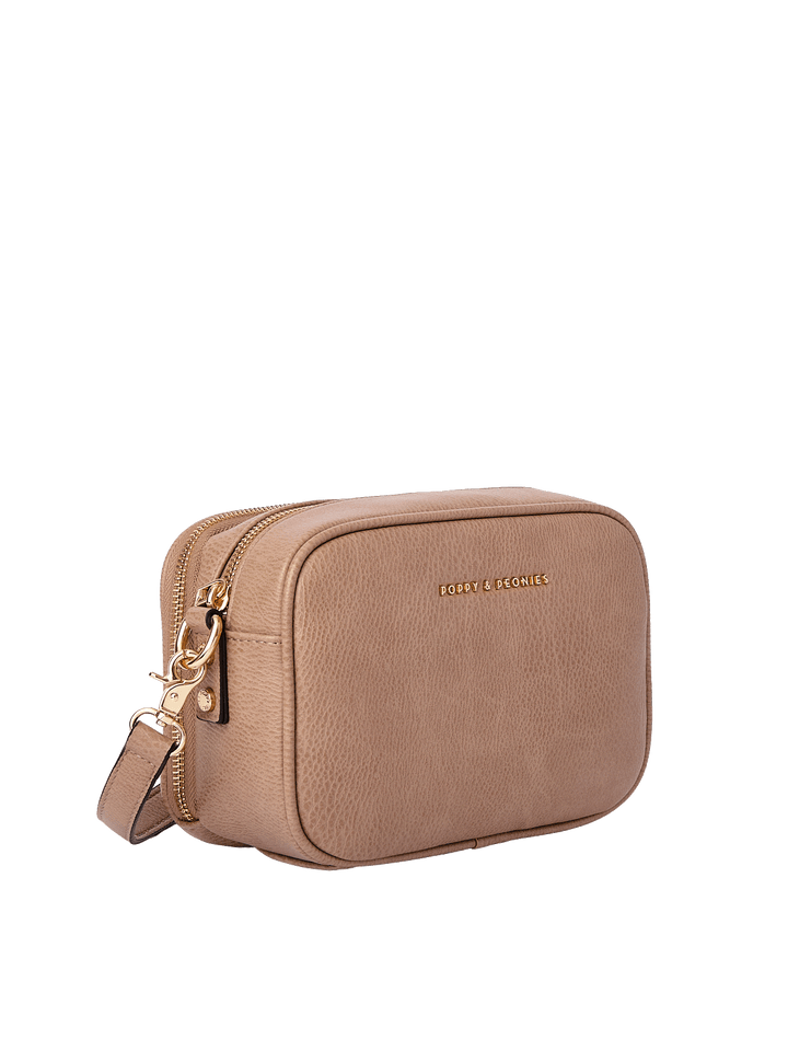 Angled view of the 24/7 Crossbody in Taupe showing structured vegan leather design