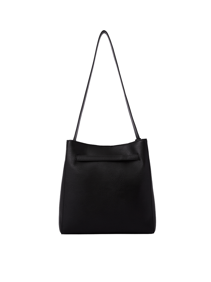 Poppy & Peonies The Knot Shoulder Bag in Black, showcasing its black pebbled exterior, long shoulder strap, and horizontal seam detail near the top.