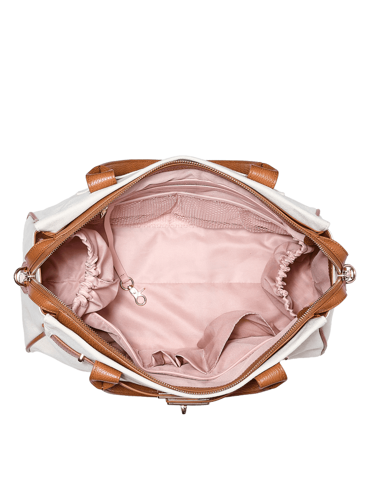 White handbag with brown vegan leather straps and trim, open to reveal pink interior.