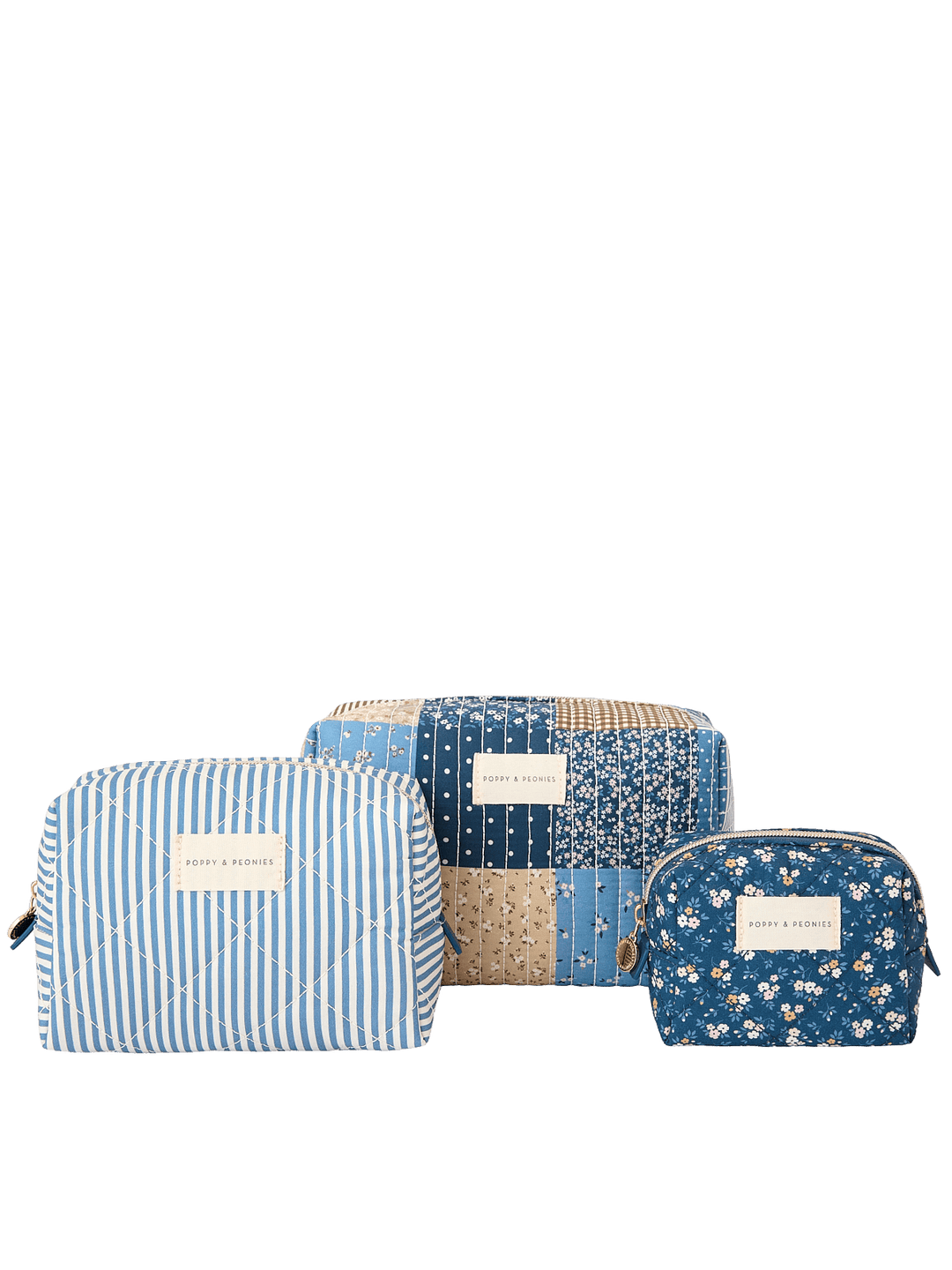 Clean product shot of the Poppy & Peonies Cosmetic Trio in Navy Patchwork, featuring all three coordinating cosmetic cases together: a blue-and-white striped case, a navy patchwork case, and a navy floral case.