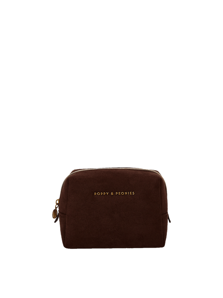 A dark brown suede cosmetic pouch with gold lettering that reads 'POPPY & PEONIES' on the front.