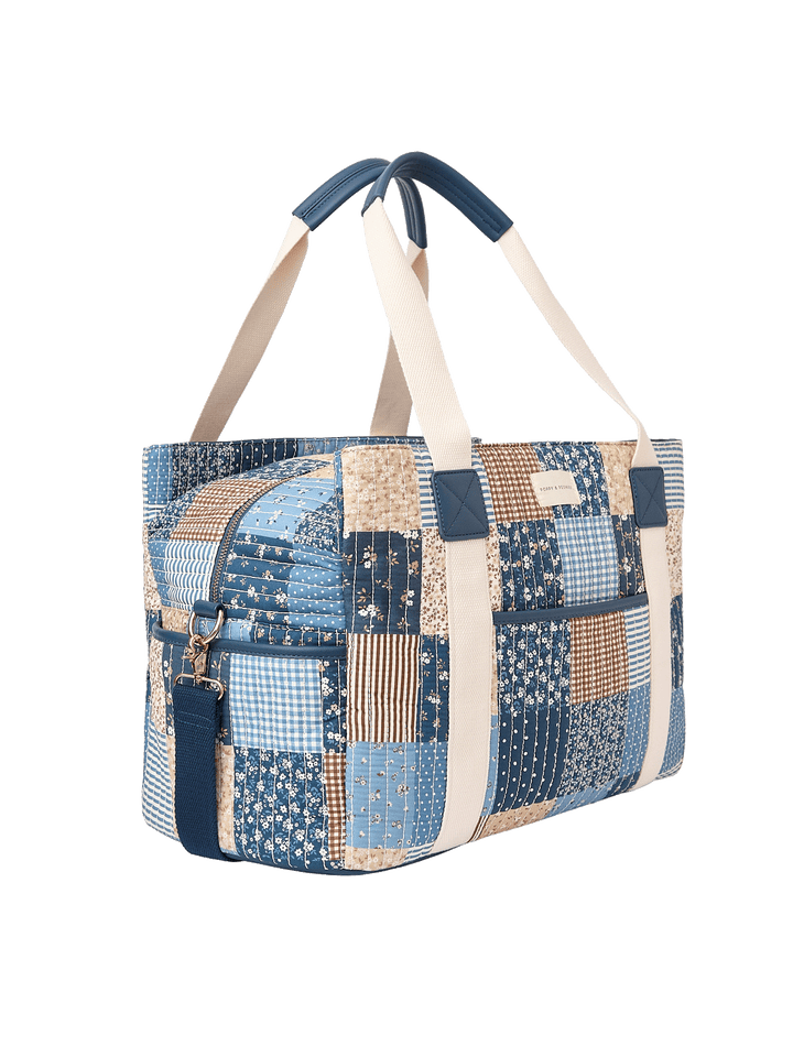 Angled side view of Mini Voyager tote in Navy Patchwork.