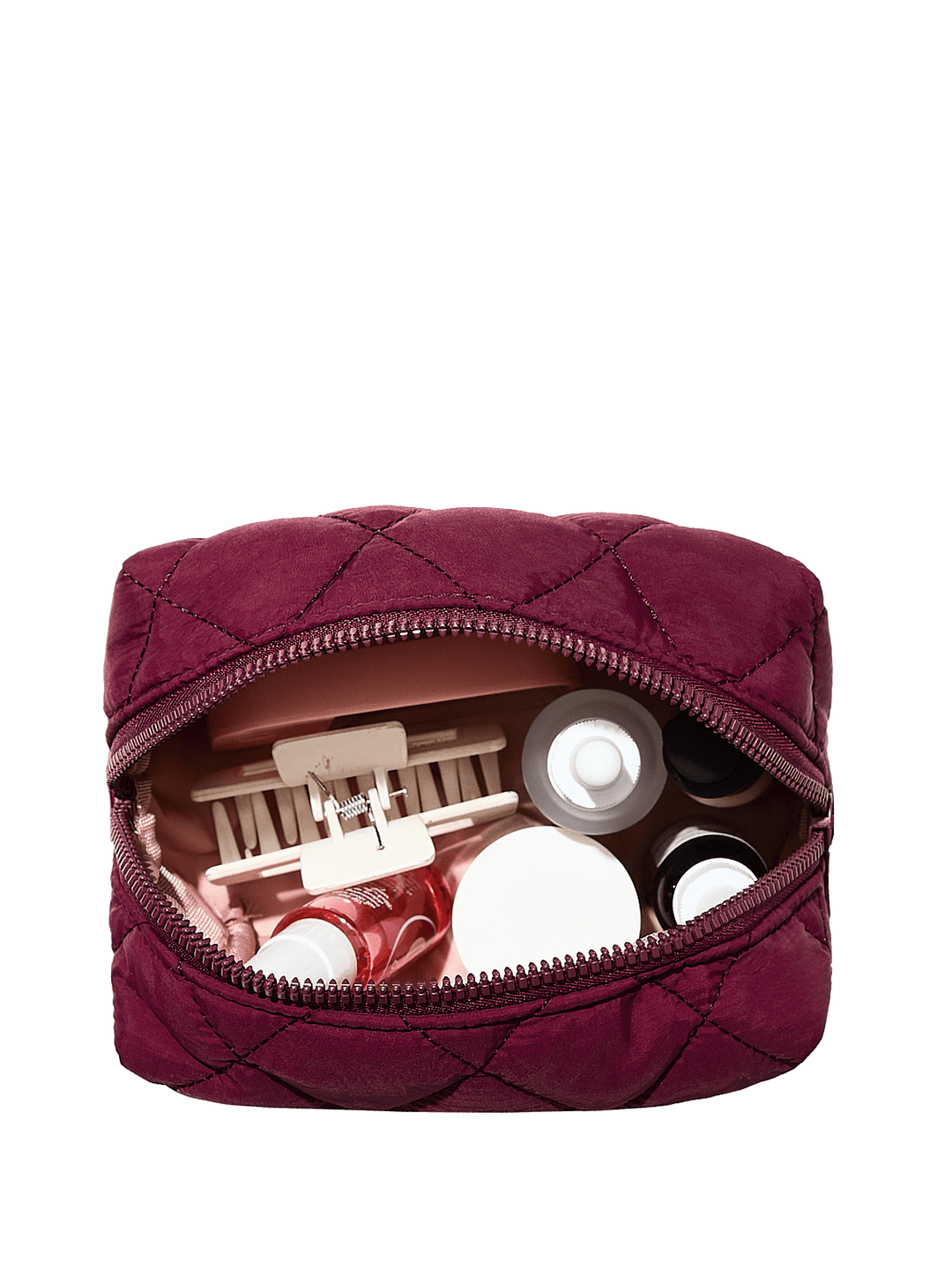 Quilted berry coloured makeup bag with cosmetic items on a transparent background