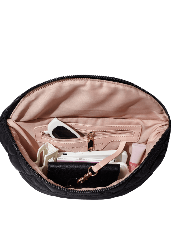 Black handbag open to reveal its contents on a transparent background