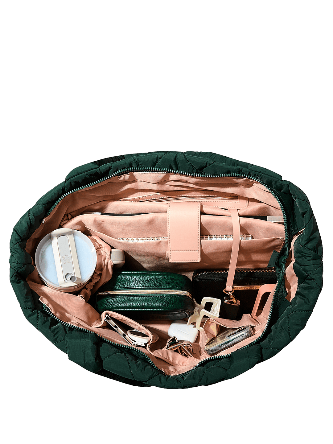 Open green quilted tote bag with various items inside