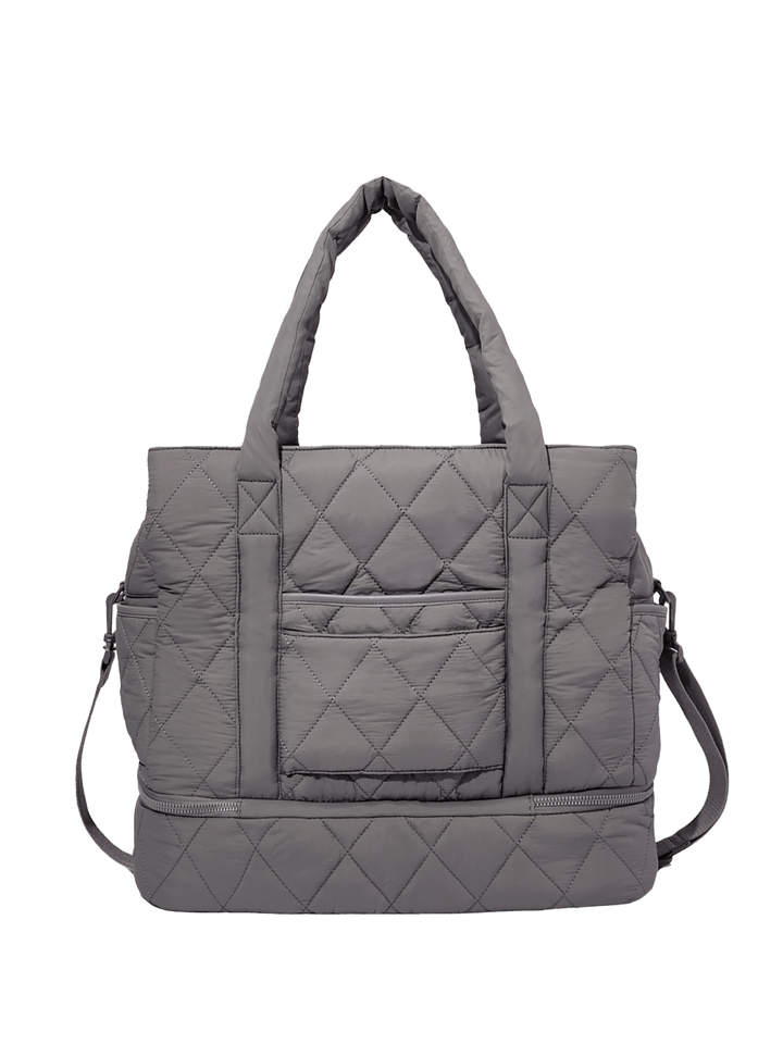 Grey quilted travel bag on a transparent background