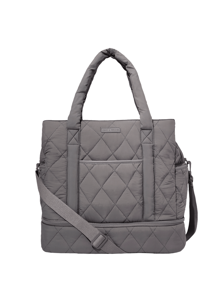 Grey quilted travel bag with a shoulder strap on a transparent background