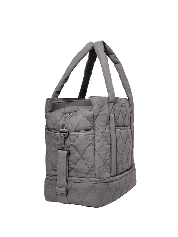 Grey quilted handbag on a transparent background