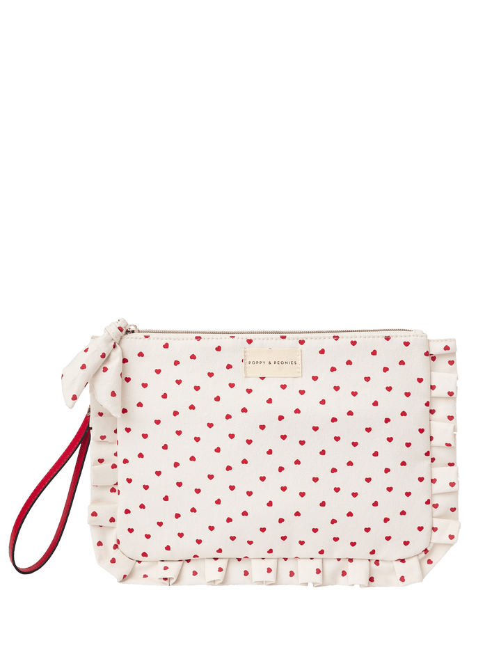 White clutch with red heart pattern and red wrist strap