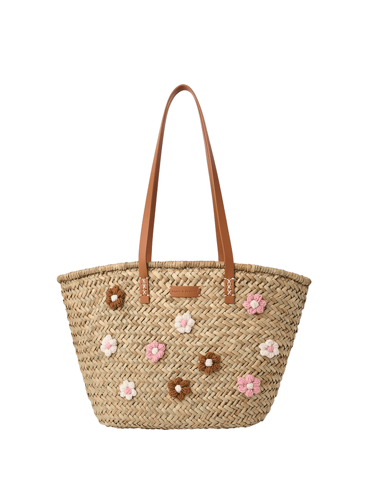 Woven straw tote with floral embellishments and brown vegan leather straps