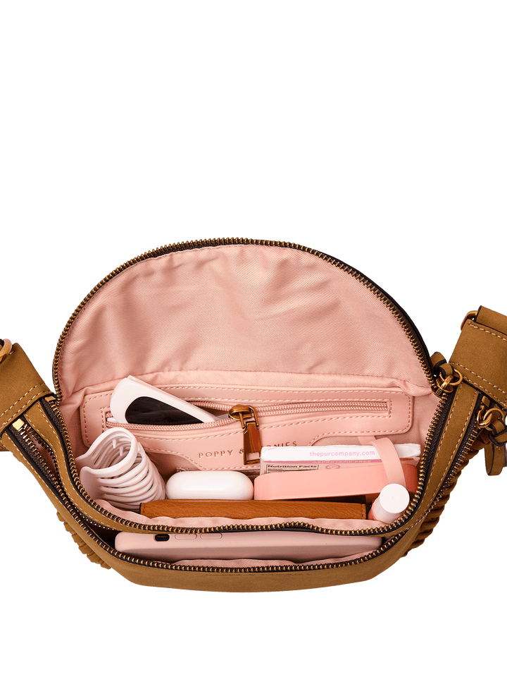 Open vegan suede belt bag with cosmetic items on a transparent background.