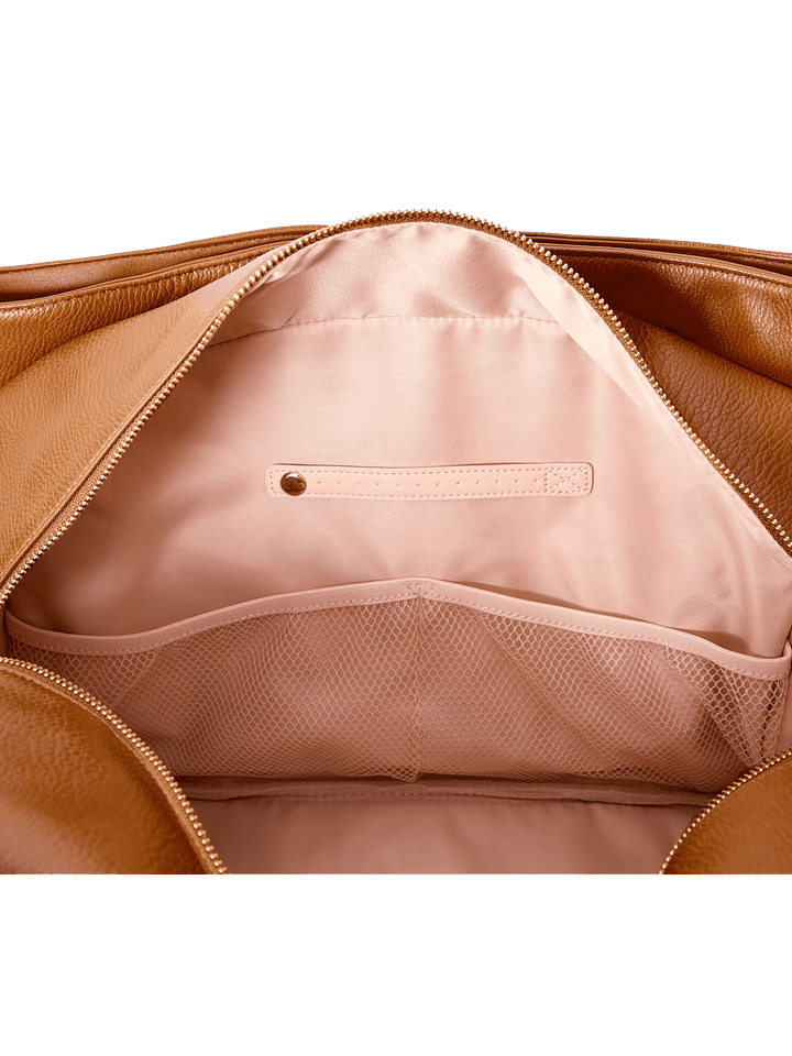 Close-up of a brown vegan leather bag with a pink interior pocket.