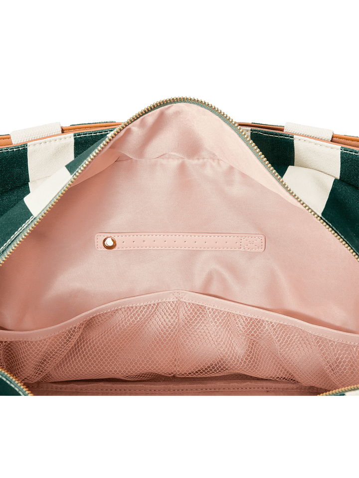 Close-up of a pink interior pocket on a green and white striped bag.