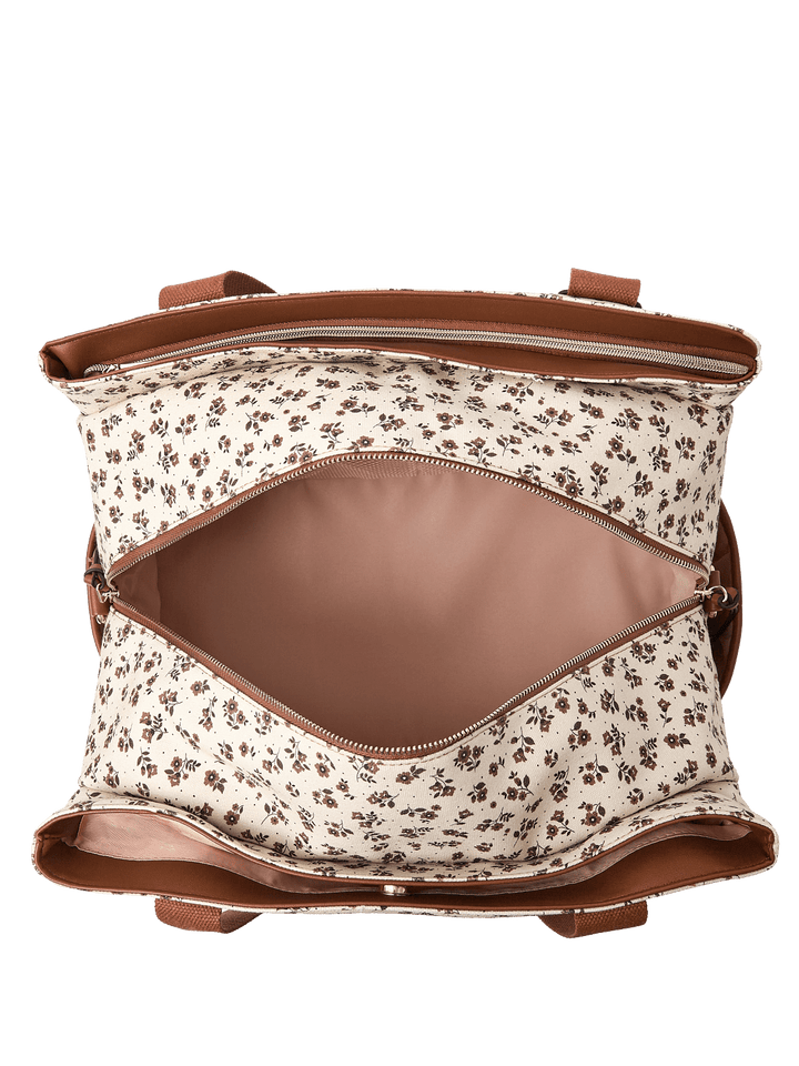 Open floral-patterned travel bag with a pink interior and brown straps