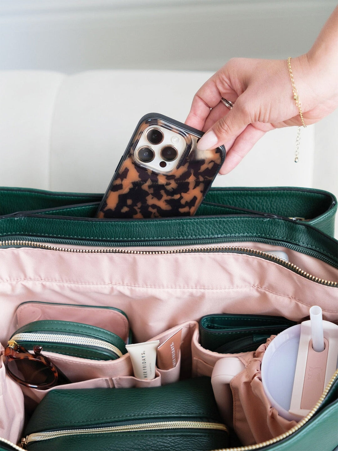 Storing phone inside the interior pocket of the Poppy & Peonies Double Duty Tote in Heritage Green.
