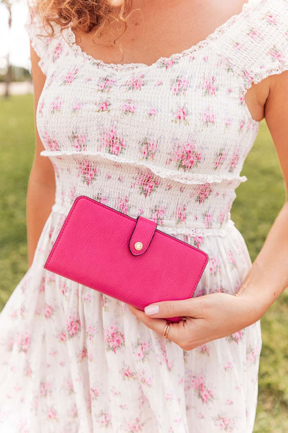 Woman holding a Poppy & Peonies Go Anywhere Wallet in pink